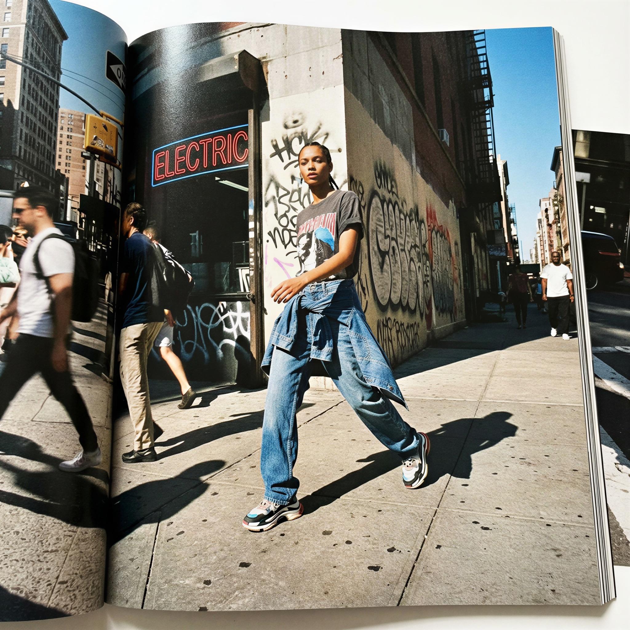 Vogue editorial style, dynamic urban street style shot, single subject, harsh midday sunlight creating strong graphic shadows on concrete and neon signs, energetic confident posing, high fashion contemporary streetwear focus, fast shutter speed capturing motion, raw authentic atmosphere, wide-angle composition, magazine quality street photography