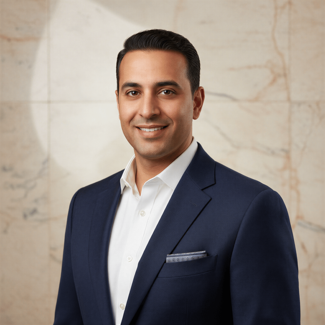 A polished headshot of a business consultant in versatile attire, set against a sophisticated, neutral background that suggests high-level client interaction.
